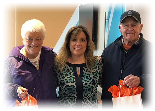 Ascentra employee standing in between our Ascentra couriers after giving them their random acts of kindness gift bags