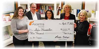 Team ascentra standing with safer foundation holding giant check for $5,000